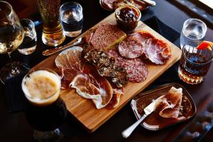 a table with a cutting board with meat and drinks at Kimpton - Armory Hotel Bozeman, an IHG Hotel in Bozeman