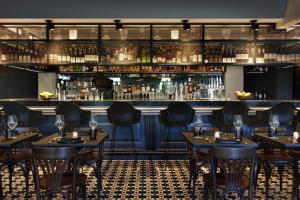 a restaurant with tables and chairs and a bar at Kimpton - Armory Hotel Bozeman by IHG in Bozeman