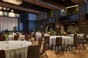 a banquet hall with white tables and chairs at Kimpton - Armory Hotel Bozeman by IHG in Bozeman