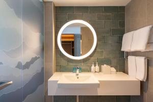 a bathroom with a mirror and a sink at Holiday Inn Express & Suites Queenstown, an IHG Hotel in Queenstown