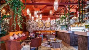 a restaurant with tables and chairs and a bar at Hotel Indigo Brussels - City by IHG in Brussels