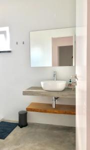 La salle de bains est pourvue d'un lavabo et d'un miroir. dans l'établissement Sunshine Patio Getaway, à Vila Nova de Milfontes