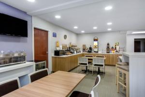 a restaurant with a table and chairs and a bar at Microtel Inn & Suites by Wyndham Burlington in Burlington