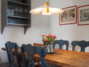 uma mesa de jantar com cadeiras e um vaso de flores em Holiday home Vrena em Vrena