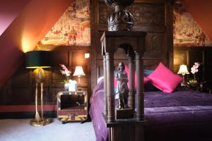 um quarto com uma cama de dossel e almofadas cor-de-rosa em Brockley Hall Hotel em Saltburn-by-the-Sea