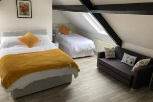 a bedroom with a bed and a couch in a attic at Temple-Effin Self Catering Holiday Cottage in Whitehead