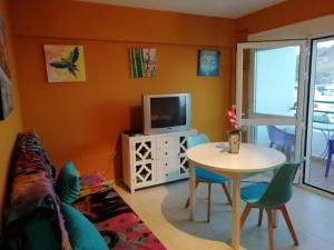 ein Wohnzimmer mit einem Tisch und einem TV in der Unterkunft El Sol de Las Negras con vistas al mar in Las Negras