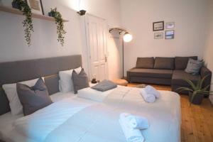 uma grande cama branca numa sala de estar com um sofá em Cosy and Spacious Apartment in the heart of Innsbruck em Innsbruck