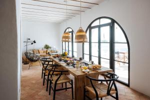 een eetkamer met een lange houten tafel met stoelen bij Aljana Guest House Beja in Beja