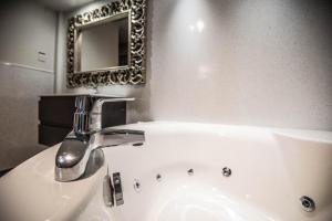 Leaside Hotel في لوتون: حمام مع حوض ومرآة