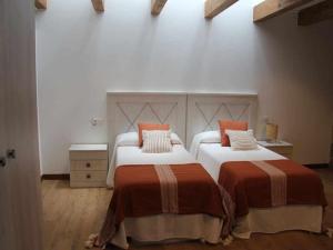 A bed or beds in a room at O Fogón Casa Ferrador Ribeira Sacra