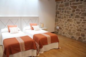 A bed or beds in a room at O Fogón Casa Ferrador Ribeira Sacra