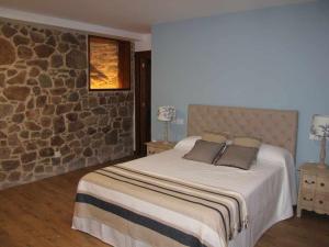 A bed or beds in a room at O Fogón Casa Ferrador Ribeira Sacra