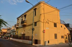 um edifício amarelo no lado de uma rua em Happy House Pompei em Pompeia