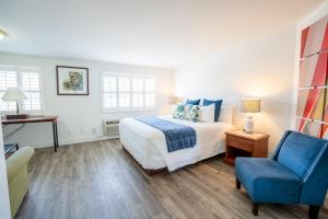a bedroom with a bed and a blue chair at La Avenida Inn in San Diego
