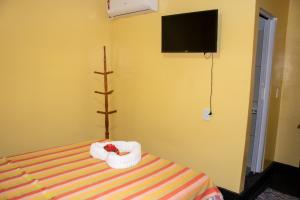a bedroom with a bed with a towel animal on it at Casa do Mestre Avila in Jijoca de Jericoacoara