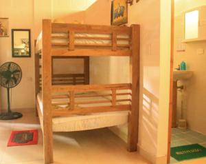 a wooden bunk bed in the corner of a room at La Natura Hostel & Pool in Palomino
