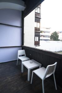 インスブルックにあるGemütliche Altbauwohnung im Zentrumの白い椅子2脚、テーブル、窓