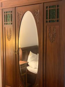 a mirror in a wooden cabinet with a bed in it at Casa AURORA in Amarante +6 photos
