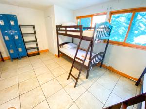 a room with two bunk beds and a tiled floor at ITH Beach Bungalow Surf Hostel San Diego in San Diego