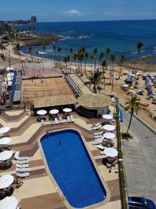 un complejo con piscina y playa con sombrillas en Ondina Apart Hotel Salvador en Salvador