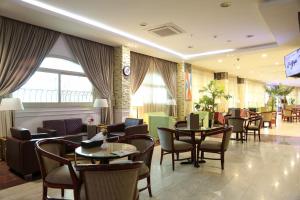 a restaurant with tables and chairs in a room at Alazhar Palace Hotel in Al Qunfudhah