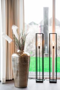 a vase with flowers in a window with three candles at New Bay in Callantsoog