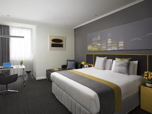 a hotel room with a bed and a desk at Citadines St Georges Terrace in Perth