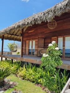 ein Holzhaus mit einem Strohdach am Strand in der Unterkunft Kabana Hotel in Prea