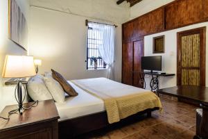a bedroom with a bed and a desk and a television at Giron Chill Out Hotel Boutique in Girón