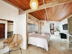 a bedroom with a white bed and a wooden ceiling at Pousada Primeira Praia Suítes in Morro de São Paulo