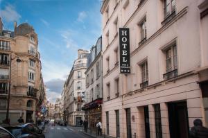 un panneau sur le côté d'un bâtiment dans une rue dans l'établissement Hôtel des Deux Avenues, à Paris