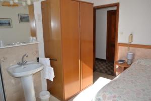 a bathroom with a sink and a cabinet and a bed at Hôtel Aïtone in Evisa