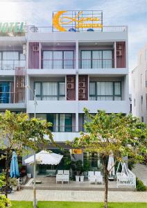 a large white building with trees in front of it at Luna Oriental in Phu Quoc