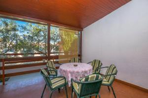 a dining room with a table and chairs and a window at Apartments Green Street in Batalaži