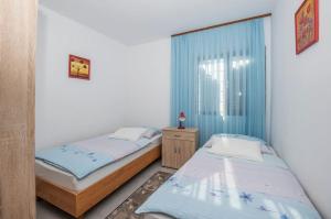 a bedroom with two beds and a window at Apartments Green Street in Batalaži