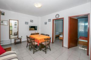 a living room with a table and chairs and a couch at Apartments Green Street in Batalaži