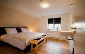 een slaapkamer met een bed, een tafel en een wastafel bij Bij Jans in Hilvarenbeek