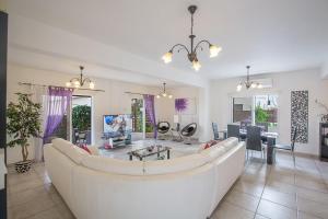 uma sala de estar com um sofá branco e uma mesa em Villa Kavo Sunshine - Beautiful 3 Bedroom Protaras Villa with Private Pool - Close to the Beach em Protaras
