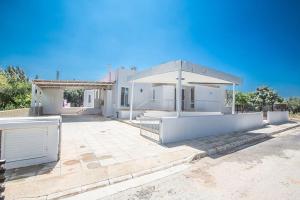 a white house with a pavilion in front of it at Villa Mavris - Lovely 4 Bedroom Villa with Private Pool in Central Ayia Napa in Ayia Napa