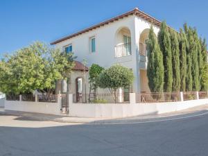 ein weißes Haus mit Bäumen an der Straßenseite in der Unterkunft Villa Foros Enas - Modern 4 Bedroom Pernera Villa with Private Pool - Close to the Beach in Protaras