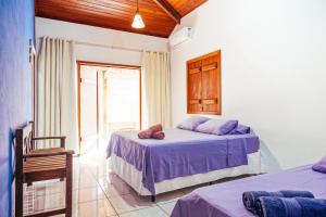 1 dormitorio con 2 camas y ventana en Surf Red House - 3 quartos c ar - 50m da Rua Principal, en Itacaré