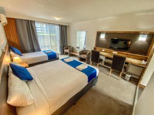 クーマにあるSnow Season Motor Innのベッド2台、薄型テレビが備わるホテルルームです。