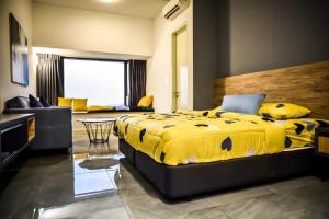 a bedroom with a yellow bed and a living room at BotakCuteHomestay@Imperio Residence in Melaka +47 photos