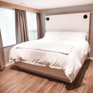 1 dormitorio con 1 cama grande con sábanas blancas en Along River Ridge, en Calgary
