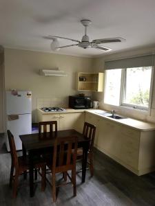a kitchen with a table and chairs and a refrigerator at RiverCottage-selfcontained in Marysville