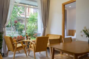 a dining room with a table and chairs and a window at Đỗ Gia Bảo Villa in Da Lat