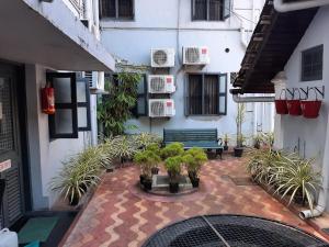 a courtyard with a bench and potted plants in a building at The Boat Jetty Bungalow in Cochin
