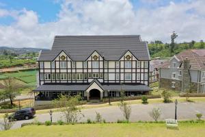 a large building with a black roof at Pedro Barn in Nuwara Eliya