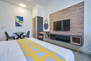 um quarto de hotel com uma cama grande e uma televisão de ecrã plano em BotakCuteHomestay@Imperio Residence em Malaca